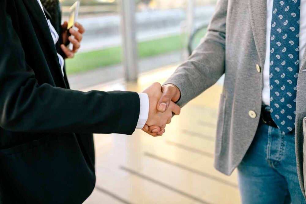 young businessman and woman shaking hands close u 2022 12 16 22 38 47 utc